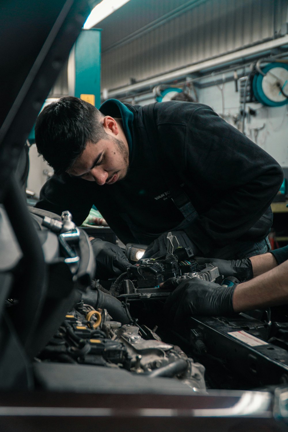 Mecánico trabajando sobre el motor de un vehículo en un taller
